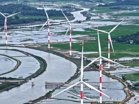 Aerial view of the Cox's Bazar 60 MW Wind Power Plant with red and white turbines set amidst winding rivers and flooded fields in Cox's Bazar, Chittagong Division, Bangladesh.