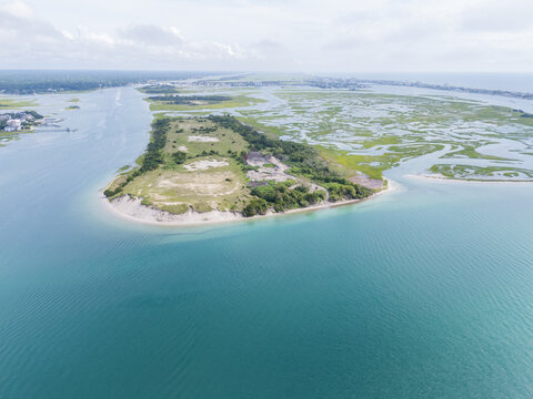Aerial view of Masonboro Island Reserve featuring sandy shores, salt marshes, and turquoise waters along the coast of Wilmington, North Carolina, United States.