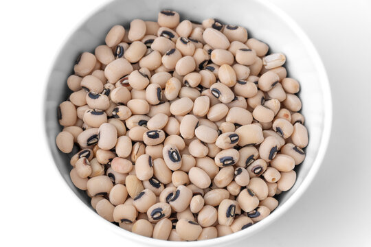 Raw dry black eyed peas beans in a white ceramic bowl isolated on white