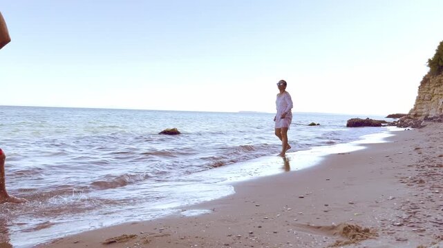 Mother and teenage son enjoying an active water ball game in the sea promoting healthy lifestyle emotional wellbeing and strong family connection. High quality FullHD footage