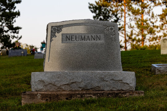 Gray granite Neumann headstone with floral corner engraving