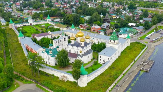 Russia, Kostroma. Holy Trinity Ipatievsky Monastery, Drone footage over white stone walls, golden domes and green rooftops along the riverbank in summer. Drone footage, Point of interest