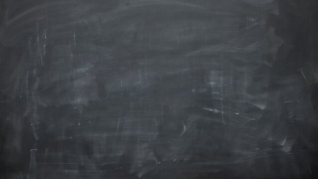 Empty dark chalkboard with dusty chalk smudges and texture for school concepts