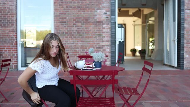 Woman sits at outdoor cafe leaving a slice of cake untouched and looks away with a proud smile after resisting dessert to support her weight loss goal and self control today