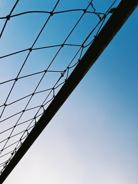 Soccer ball net frame against a clear bright blue sky creating an inspirational mood of outdoor sports