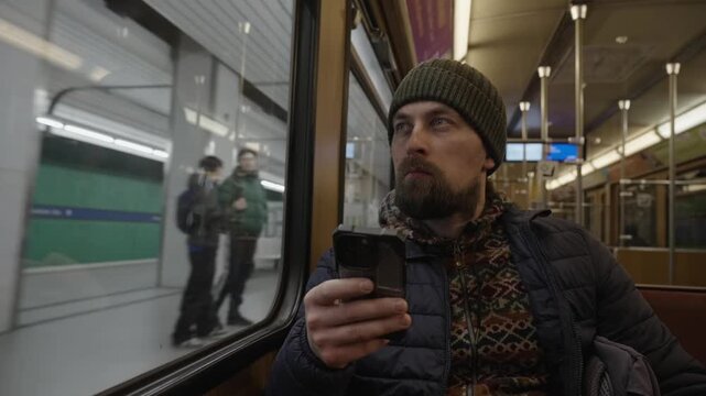 Authentische Szene im oeffentlichen Nahverkehr: Passagier mit Smartphone im historischen U-Bahn-Wagen. Vintage Design und Retro-Look der Muenchner Verkehrsgesellschaft (MVG).