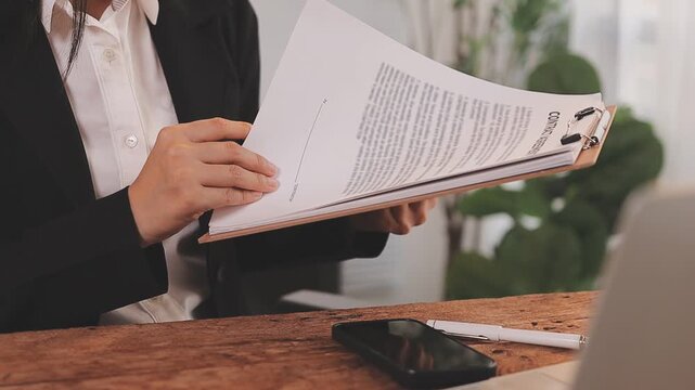 Legal advisor is explaining the offense under the law in the book at office.