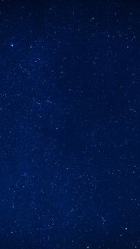 Deep blue night sky filled with stars in a vertical composition. Celestial space background for mobile designs, social media, posters, astronomy projects and creative digital layouts.