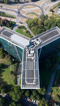 Aerial view of the Eni S.p.A. 1 Palazzo Uffici building with its distinct Y-shaped architecture, rooftop mechanical systems, and surrounding parkland in San Donato Milanese, Lombardia, Italy.
