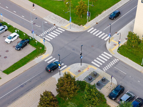 Aerial view of a road intersection with cars, crosswalks, and surrounding green spaces in Vilnius, Vilnius County, Lithuania.