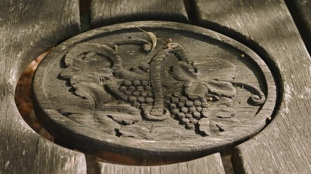 M&eacute;daillon en bois sculpt&eacute; avec grappes de raisin sur une table &agrave; Ch&acirc;teau-Chalon