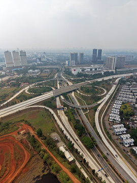Aerial view of the BSD Main Toll Gate interchange featuring multi-level highway ramps, surrounding high-rise buildings, and urban development in Kecamatan Pagedangan, Banten, Indonesia.