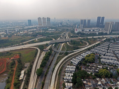 Aerial view of BSD Main Toll Gate interchange with multi-level highway lanes, surrounding residential housing complexes, and modern buildings in Kecamatan Pagedangan, Banten, Indonesia.
