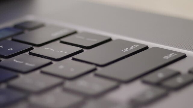 Close up macro of hands typing on laptop keyboard computer
