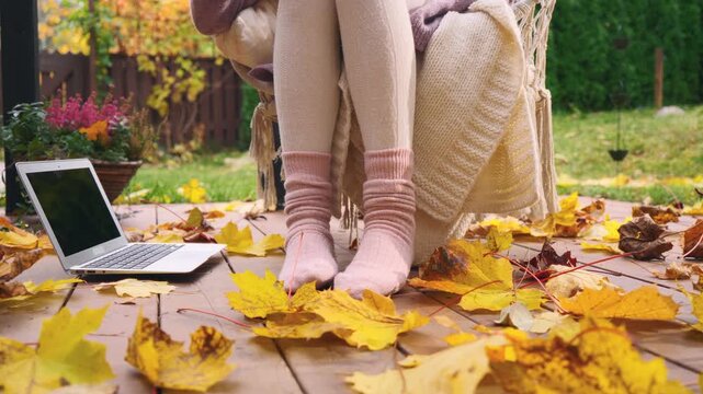 Autumn home office mood with coffee, laptop, and cozy socks. Peaceful fall morning atmosphere, freelance work and slow living lifestyle with comfort and productivity.