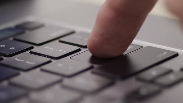 Close up macro of hands typing on laptop keyboard computer