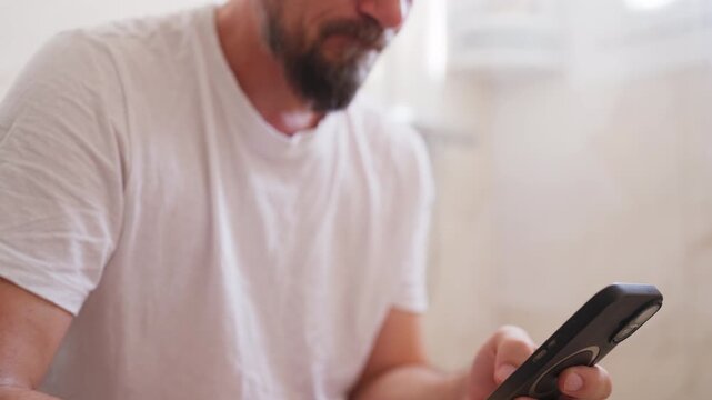 Mature man using smartphone while sitting on toilet in bathroom during a private personal moment and  masturbating , Concept  adult lifestyle, digital habits, privacy and intimate everyday behavior.