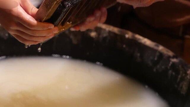 Handmade papermaking. The hands of a craftsman create paper from recycled cotton using a traditional mold and frame with torn edges.