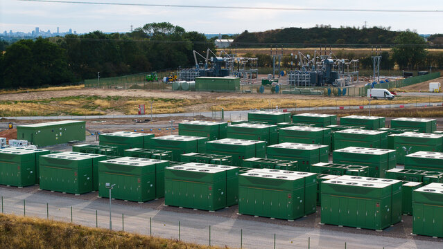 Aerial view of battery storage systems with rows of green containers at a power facility in Birmingham, England, United Kingdom.