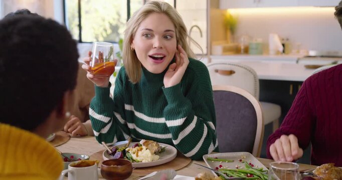 Friends dining, mustard sweater hand reaching food, blonde woman lifting cocktail and toasting