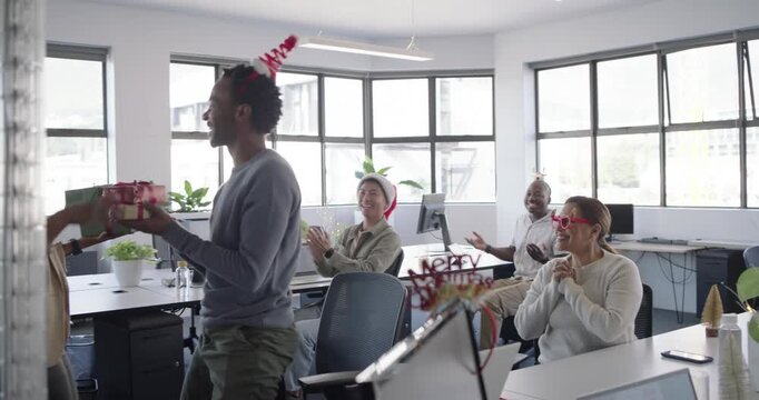 Diverse coworkers exchanging presents after gift offering for gift swap, hugging