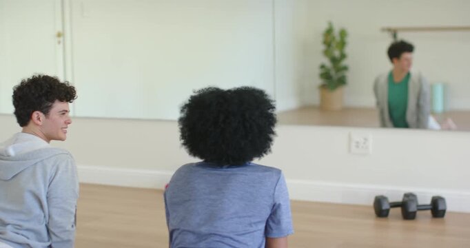 Diverse friends in sportswear lifting into cobra stretch on yoga mats after mutual glance at mirror