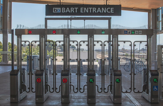 BART entrance fare gates at a transit station in Fremont, California with modern turnstiles for commuters