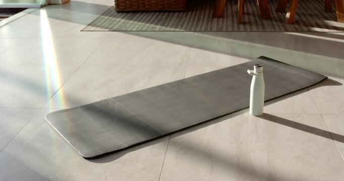 Camera is panning upward to reveal gray mat and white bottle near door, exposing living area