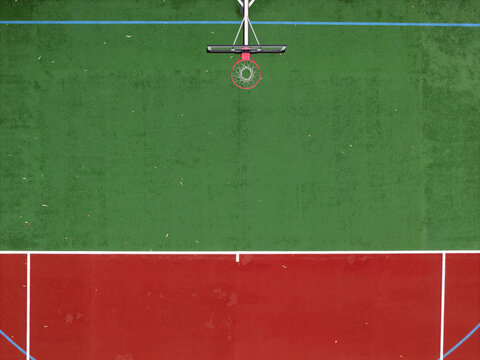 Aerial view of a basketball court with green and red surfaces and a basketball hoop in Gdansk, Poland.