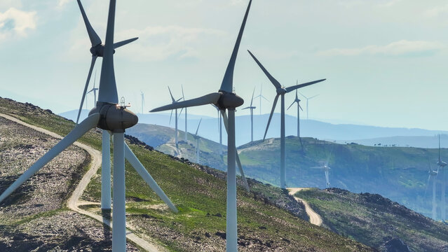 Aerial view of a wind farm with multiple wind turbines across a mountainous landscape, representing renewable energy and clean power in Lisbon, Lisbon, Portugal.