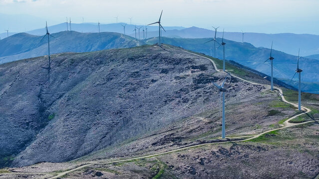 Aerial view of a wind farm with multiple wind turbines across a mountainous landscape, representing renewable energy and clean power in Lisbon, Lisbon, Portugal.