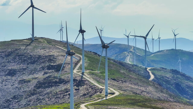 Aerial view of a wind farm with multiple wind turbines across a mountainous landscape, representing renewable energy and clean power in Lisbon, Lisbon, Portugal.