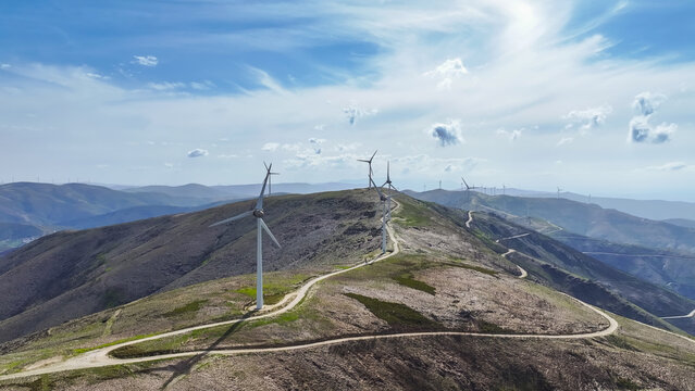 Aerial view of a wind farm with multiple wind turbines across a mountainous landscape, representing renewable energy and clean power in Lisbon, Lisbon, Portugal.
