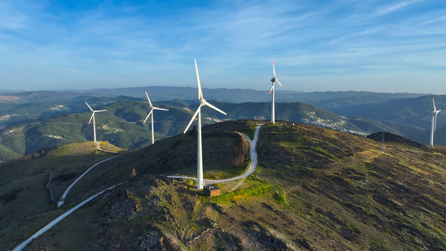 Aerial view of a wind farm with multiple wind turbines across a mountainous landscape, representing renewable energy and clean power in Lisbon, Lisbon, Portugal.