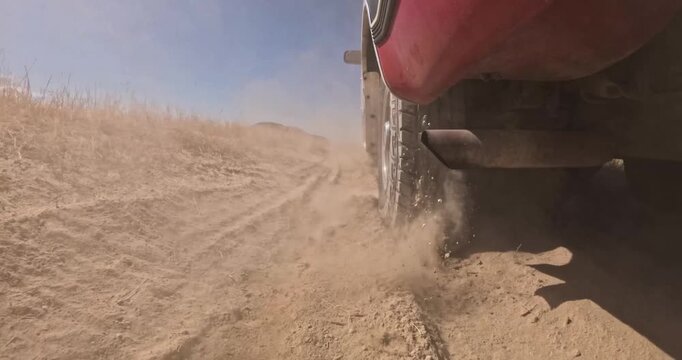 Off-road vehicle drives through dusty terrain