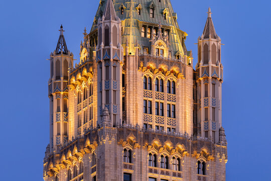 UNITED STATES, NEW YORK CITY, LOWER MANHATTAN. THE WOOLWORTH BUILDING ILLUMINATED AT DUSK, SHOWCASING ITS GOTHIC REVIVAL ARCHITECTURE BY CASS GILBERT, AN ICONIC LANDMARK