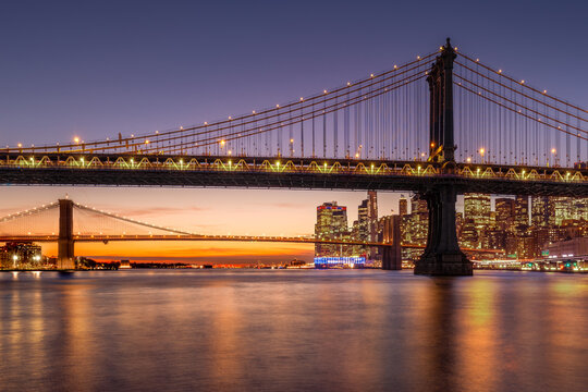 UNITED STATES, NEW YORK CITY, LOWER MANHATTAN. SKYLINE AT DUSK WITH MANHATTAN BRIDGE AND BROOKLYN BRIDGE AND EAST RIVER JUST AFTER SUNSET