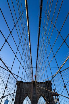 UNITED STATES, NEW YORK CITY, MANHATTAN, LOWER MANHATTAN. SUSPENSION CABLES AND WEST TOWER OF BROOKLYN BRIDGE WITH BLUE SKY