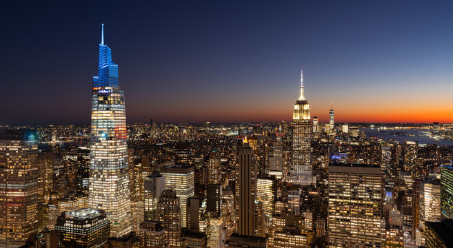 UNITED STATES, NEW YORK CITY, MANHATTAN. ELEVATED SKYLINE VIEW OF THE SKYSCRAPERS OF MIDTOWN MANHATTAN ONE VANDERBILT ON THE LEFT AND EMPIRE STATE BUILDING AT CENTER AT TWILIGHT
