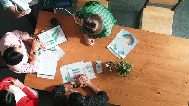 Top down aerial view of smart business man hold tablet and show financial chart at meeting table with financial document. Manager placed tablet at table while investor looking at graph. Convocation.