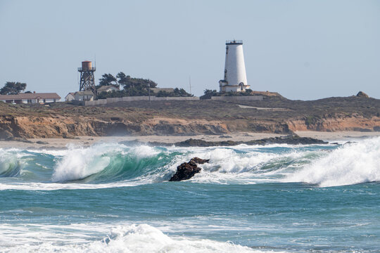 Historic 19th-century Piedras Blancas Light Station on coastal headland above crashing Pacific Ocean waves, San Simeon, California, USA, August 2026.
