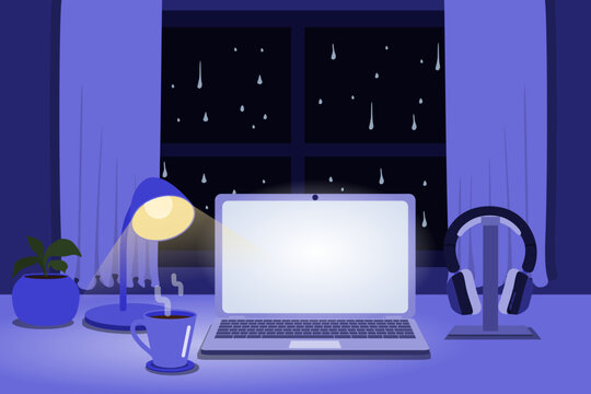 Cozy rainy night home office with laptop, headphones, coffee and desk lamp