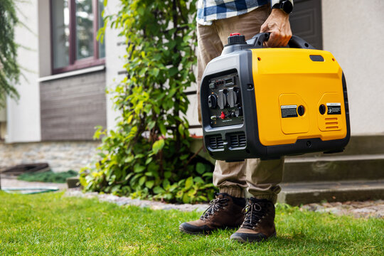 Man carrying portable generator for emergency home power supply
