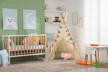 Cute baby room interior with comfortable crib, wigwam and other toys © New Africa