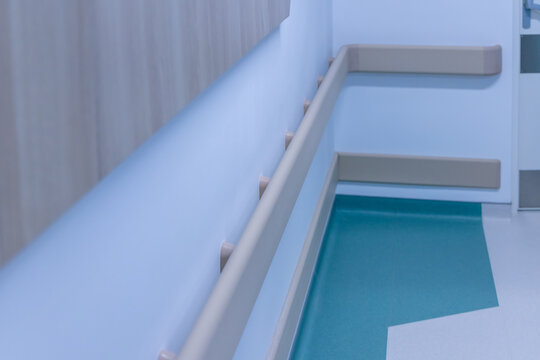 Wall handrails and corner guards line a hospital corridor. The rails give support to patients who walk on their own, the guards protect the walls. Safety and accessibility in a new hospital