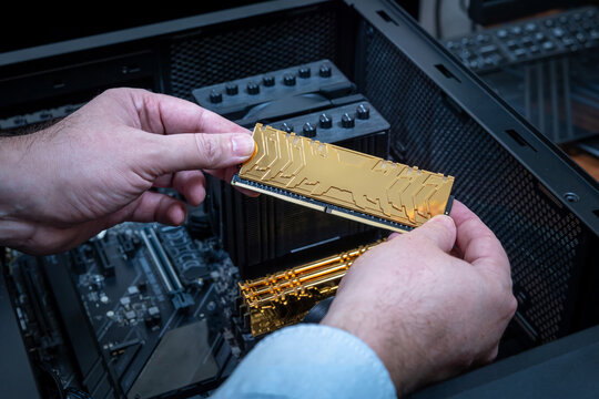 Golden DDR module held in technician's hand symbolizing rising cost of RAM due to AI market demand. Used for high-end gaming or workstation upgrades. Price increase on computer memory