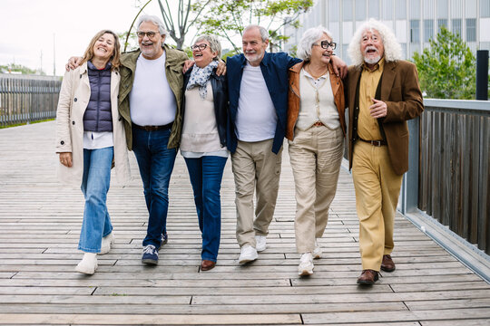 Group of active seniors walking outdoors, embracing friendship and enjoying an active healthy lifestyle, showcasing community and togetherness in their golden years journey