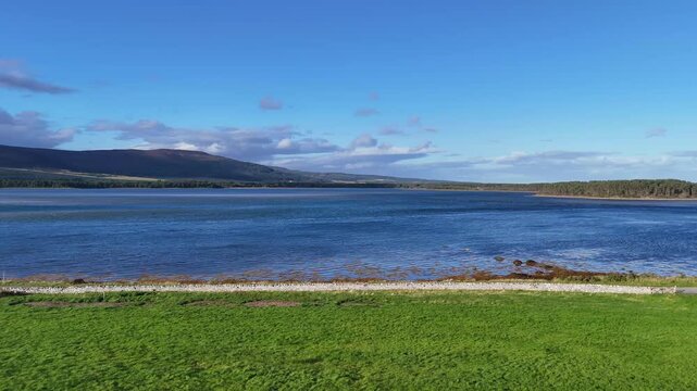 High angle aerial shot of scenic tidal basin and grassy coastline at Loch Fleet nature reserve near Dornoch Scotland