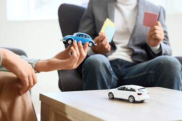 Car insurance and vehicle purchase planning, agent and client discussing auto finance options with...
