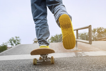 Legs of young man with skateboard in skatepark, closeup © Pixel-Shot
